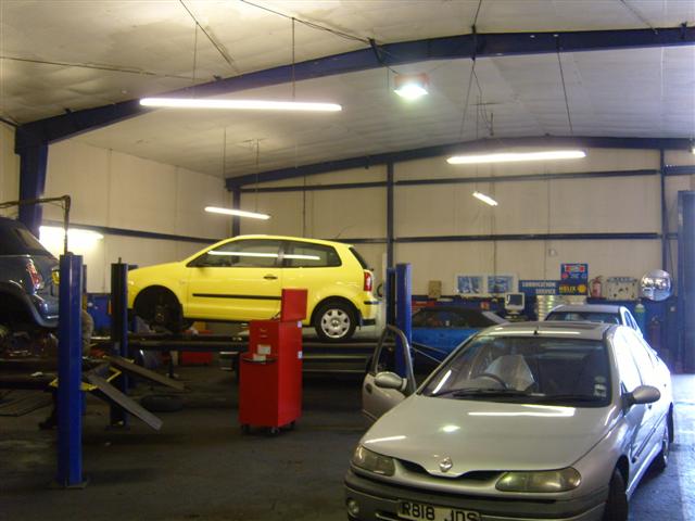 inside the garage with two cars ready for repairs